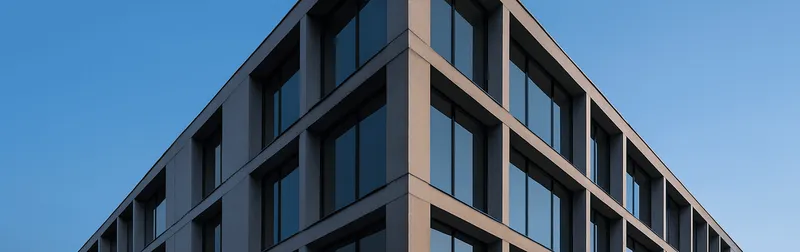 Architekturfotograf in Wien fotografiert eine moderne Glasfassade mit geraden Linien in der blauen Stunde