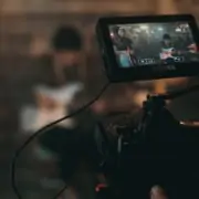 Eine Person hält eine Videokamera vor eine Person.