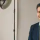 Professionelle Bewerbungsfotos im Fotostudio in Wien: freundlicher Bewerber im Sakko vor hellgrauem Hintergrund unter Studiolicht