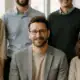 Einheitliche Teamfotos eines Unternehmensteams im hellen Büro in Wien, professionelles Gruppenfoto für Website und Karriereseite